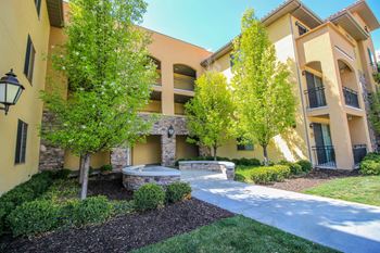 A sunny day at apartment complex with a small garden in front.